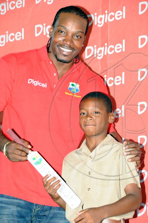 Rudolph Brown/Chief Photographer
West Indies' captain Chris Gayle present a bat to Ronaldo Fletcher student of Excelsior Primary during a Digicel cricket experience at Excelsior High School on Wednesday, June 24-2009