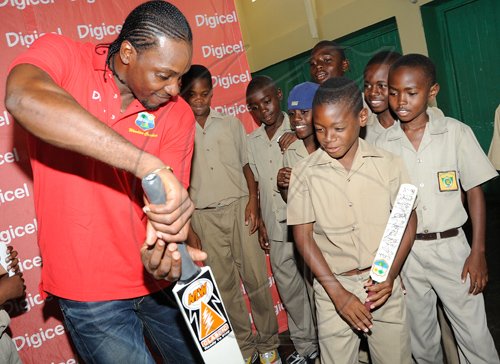 Rudolph Brown/Chief Photographer
West Indies' captain Chris Gayle show students from Excelsior Primary his batting technique during a Digicel cricket experience at Excelsior High School on Wednesday, June 24-2009