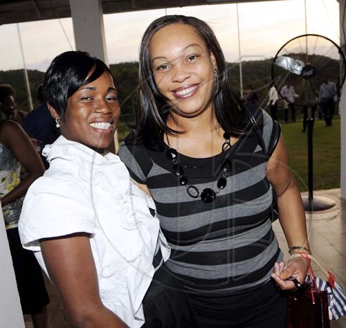 Rudolph Brown/Photographer Dehandro Braithwaite (left) and Vinnett Myers are in the party mood.  **********************************************************************, at the St. Catherine Co-operative Credit Union Christmas awards luncheon at Caymanas Golf and Country Club on Wednesday, December 22-2010