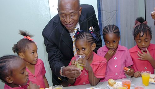 Rudolph Brown/Chief Photographer
Randolph McLean, Senior Branch Manager Sagicor feed students from One Way Early Childhood at the Adopt-A-School launch ceremony at the Sagicor Office in New Kingston on Thrusday, March 19-2009.