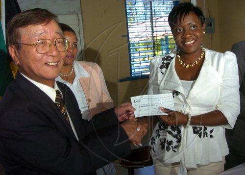 Ricardo Makyn/Staff Photographer.
Left His Excellency,Masahiro Obata Ambassador,Embassy of Japan presents a Cheque to Stacy-Ann Nelson Acting Manager of the Maxfield Park Children Home while looking on is Alison Anderson Chief Executive Officer  at the  grant contract signing ceremony between the Embassy of Japan in Jamaica and the Maxfield Park Childrens Home for a renovation project on Thursday 19.3.2009.