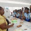 Ian Allen/Staff Photographer
Elsa Codling, left, Food and Nutrition teacher at Papine High School puts the finishing touches to a cake on display at the school's Open Day, under the watchful eyes of student in attendance.