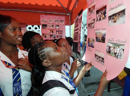 Headline: Papine High turns 50

Ian Allen/Staff Photographer
Students of Papine High School look at charts depicting different time-periods in their institution's history. The school was celebrating its 50th anniversary and Open Day on its grounds yesterday.