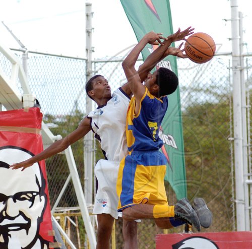 Ricardo Makyn/Staff Photographer.
Ardenne High's Joseph Thomas is blocked by Jamaica College's Jhevon Redman during their ISSA KFC All-Island Under-16 final at the National Stadium Court on Thursday. JC won 53-51 for their first hold on the title.