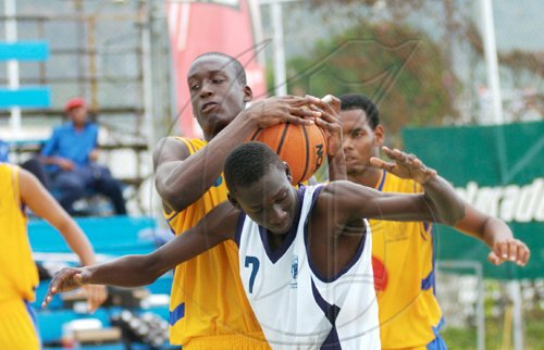 Ricardo Makyn/Staff Photographer
Ardenne High's Stephen Silvera (left) and Jamaica College's Sekou Brown (centre) tussle for possesion during the ISSA KFC All-Island Basketball Under-16 final at the National Stadium Courts yesterday. JC won the game 53-51 for their first ever hold on the championship.  See more on page 57.