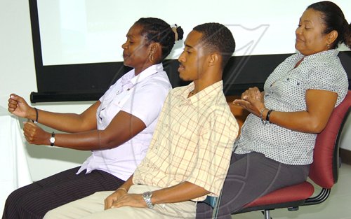 Rudolph Brown/Chief Photographer
Evette Bugridge, (left), Davion Webber and Kathe Lyn, (right) from Lister Mair Gilby School for the Deaf performing a skit driving car for a license at the Island Traffic Authority launches sign language training to enable the testing and certification of deaf drivers at PIOJ, 16 Oxford Road on Wednesday, March 11-2009