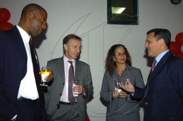 Peta-Gaye Clachar/Staff Photographer
President and CEO of JPS Damion Obiglio (right) have talks with Wayne Henry (left)from the Ministry of Agriculture, Jack Noble the Executive Vice President of Fijitsu America and Francis Correia Executive Vice President of Service of Fijitsu in the Caribbean at the Fijitsu executive cocktail reception at their Belmont Road office on Thursday, March 12, 2009.