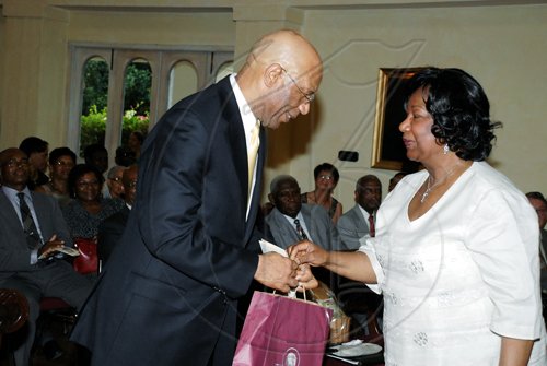 Colin Hamilton/freelance photographer
Governor General Sir Patrick Allen receives a git from Dr Thelma Thompson, guest speaker at the launch and president of the University o Maryland, Eastern Shore.

******************************************************************* The Gilbert and Georgia Allen Educational Trust launch at Kings House on Thursday March 25, 2010.