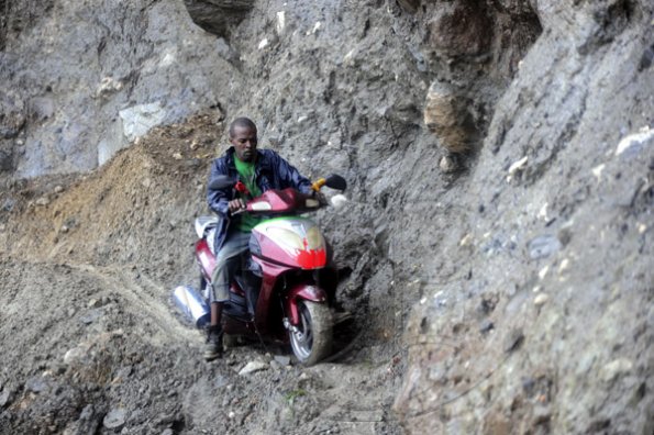Ricardo Makyn/Staff Photographer.
John Beckford dangerously rides His bike along whats left of a embankment at Friday in the  Rio Grande Valley after Rainfall had caused a Landslide that totally destroyed what was left of the roadway .