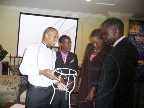 M.A.D.E. scholarship winners Michael Dixon and Andrae Barrett show off their projects for  Opposition Spokesman on Education, Basil Waite, and Courts Research Director Carolyn Thomas at the Courts Award ceremony on August 13, 2009.