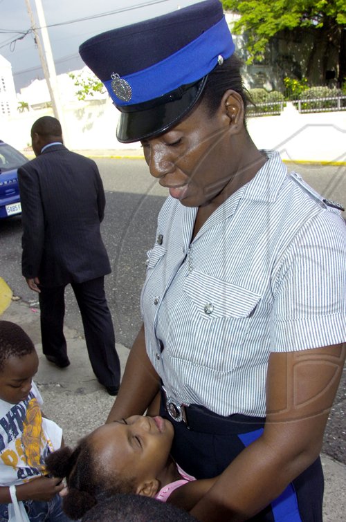 Norman Grindley/Chief Photographer Woman constable Donna Lindsay, assigned to to the house of parliament in Kingston find a new friend yesterday. The occasion was was a Christmas treat put on by staff at the House for children in the area.