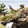 Norman Grindley /Chief Photographer
A soldier slides from an armoured vehicle as he gets ready for action in West Kingston on Monday.