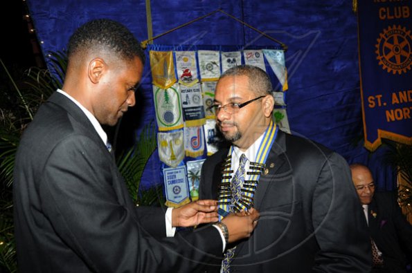 Rudolph Brown/Photographer
Outgoing president Donovan Brown (left), adjusts the collar on newly-installed president David T. Brown at the Rotary Club of St Andrew North Installation ceremony at RibKage, St Andrew on Monday, June 28, 2010.