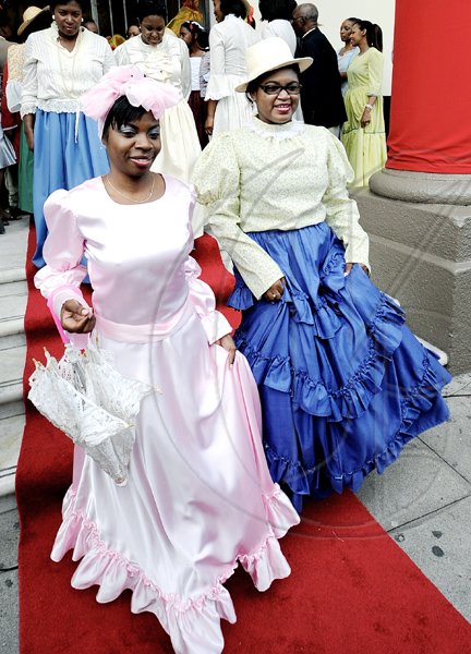 Rudolph Brown/Photographer
 Scotiabank staff Cornelia Ceough (left) and Martine Nelson, walk the red carpet during the bank's celebration of 120 years in Jamaica at the King  Street Branch on Monday, December 14.