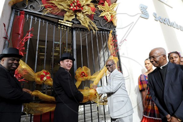 Rudolph Brown/Photographer
Mayor of Kingston Desmond McKenzie, (right), Bruce Bowen, (centre) President and CEO of Scotiabank Group Jamaica and Michael Shaw, (left) Scotiabank Kings Street branch Manager cutting the ribbon to official opening the bank for the Scotiabank Jamaica celebrating 120 years in Jamaica from 1889 to 2009 at the Kings Street Branch on Monday, December 14-2009