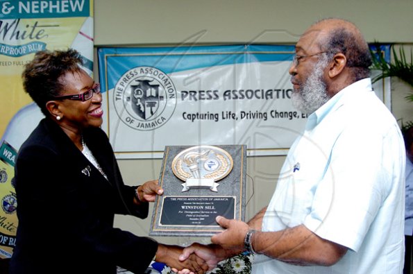 Peta-Gaye Clachar/Photographer
Director of Public Prosecutions Paula Llewellyn, guest speaker at the PAJ Veterans' Luncheon, presents The Gleaner's Winston Sill with an award for his photographic coverage over the years. 









outstanding contribution and service at a Veterans' Luncheon hosted by the Press Association of Jamaica at the Girl Guides Association on Wednesday, December 2, 2009. Mr. Michael Gordon Photographer from the Jamaica Observer, Mr. Ken Dawson Videographer formerly at TVJ and Mr. Ruddy Mattherson a Videographer were also honoured.