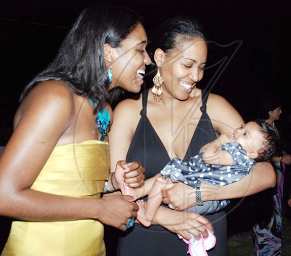 Colin Hamilton/freelance photographer
Loving mom Tamia Tryon (right) cuddles baby girl Maia while doting aunt Sandia Harris looks at the little angel. Tryon and Harris are the daughters of UWI Vice Chancellor Prof. E. Nigel Harris and they were out at his end-of-year reception at Long Mountain Road on Tuesday.
 December 29, 2009.
